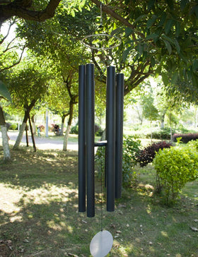 Afirst large wind chimes in a serene garden setting.