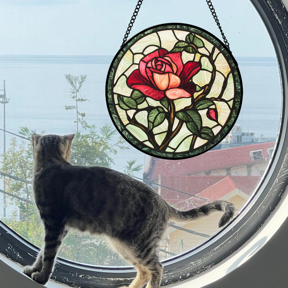AMDERVEN stained glass suncatcher in sunlight creating warm glow.