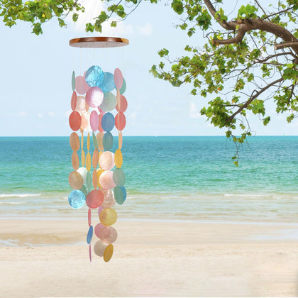 ASTARIN Capiz wind chime outdoors with iridescent glow in sunlight