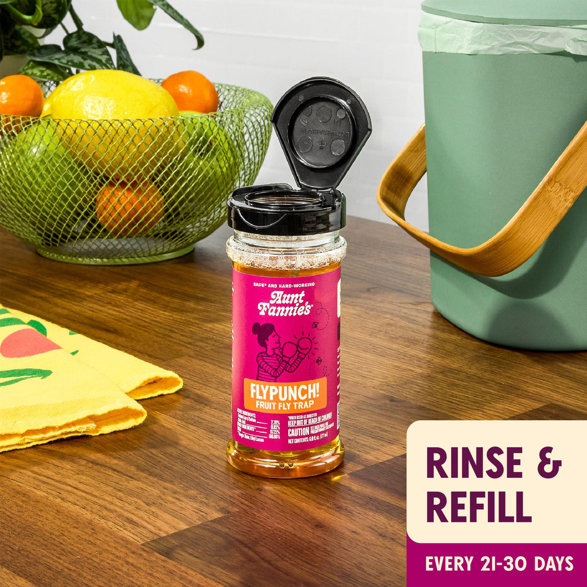 Aunt Fannie's FlyPunch bait attracting fruit flies near produce and bins.