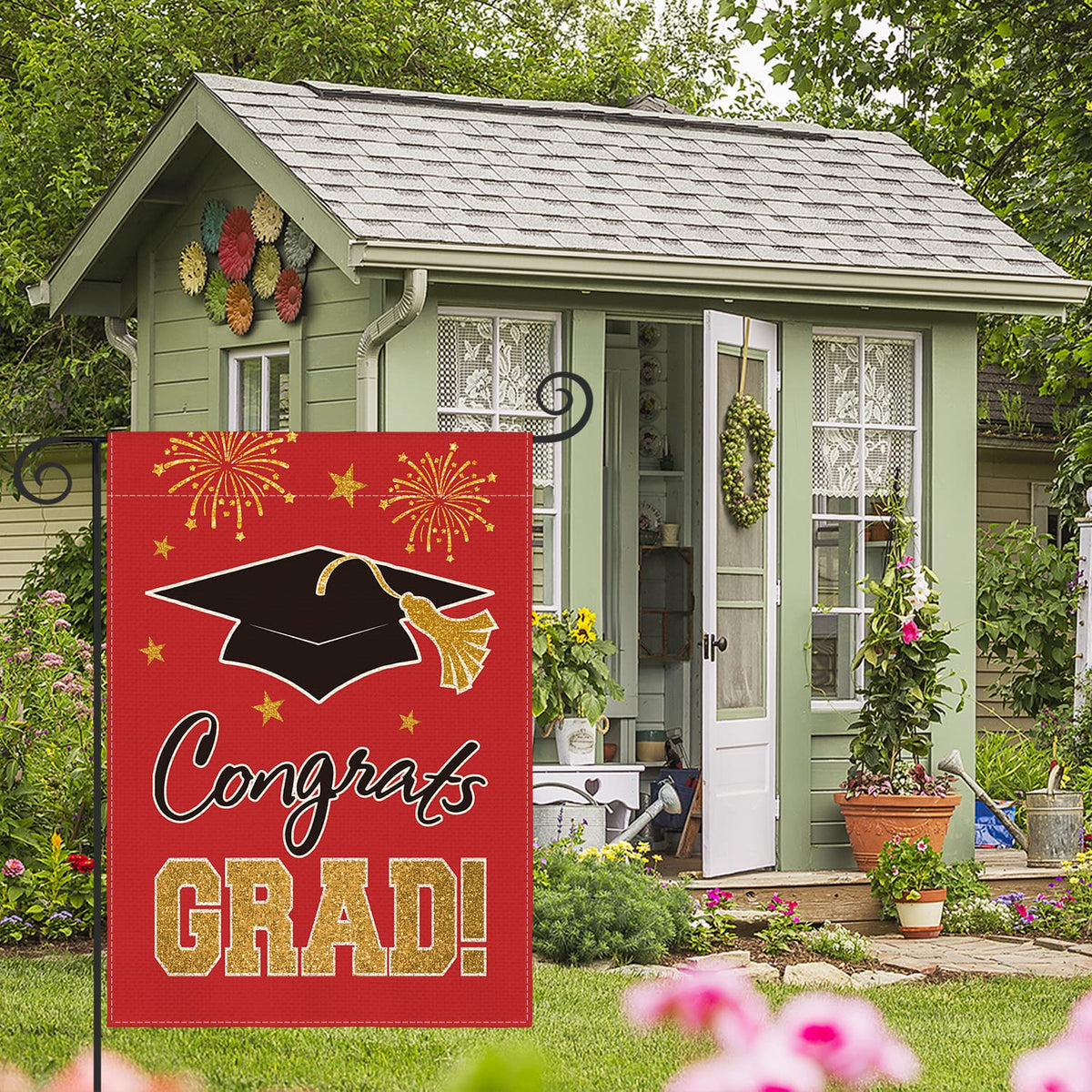 AVOIN colorlife double-sided graduation flag visible from both sides in a garden