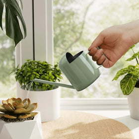 Bamworld avocado green small watering can on a desk for compact plant care