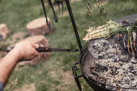 Barebones hanging design matches Cowboy Fire Pit Grill setup for tidy storage