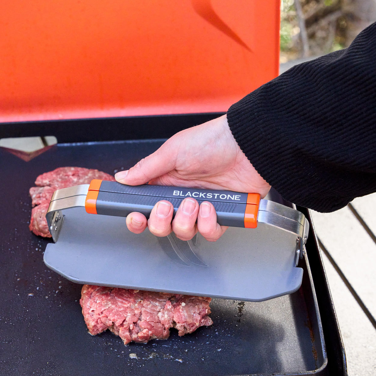 Blackstone 5987 OTG collapsible griddle press on coated griddle surface for smooth operation.