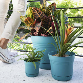 Saturn planter with snap-in saucer catching excess water and protecting surfaces.