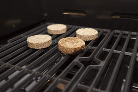 Bradley Smoker Pecan Bisquettes in use on grill with rising smoke for enhanced flavor.