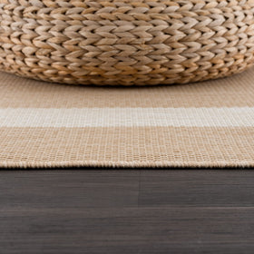 CAMILSON washable outdoor rug being hose-cleaned for quick cleanup.