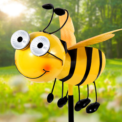 Canabear metal bee with solar eyes glows at night for outdoor ambience.
