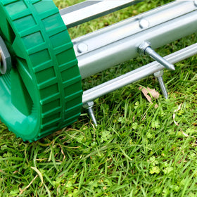 Close-up of Colwelt aerator 1.4-inch spikes penetrating the soil.