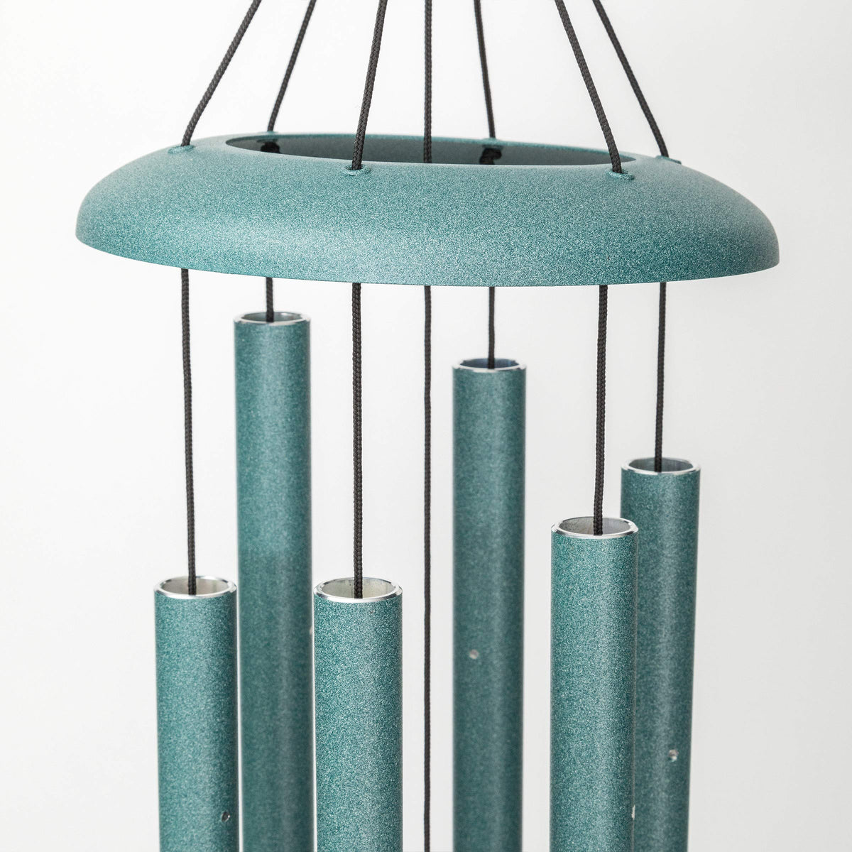 Side view of Corinthian Bells patina green chime in garden setting