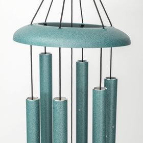Side view of Corinthian Bells patina green chime in garden setting