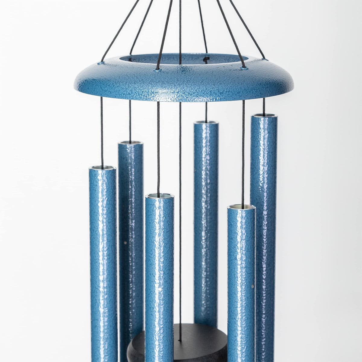 Corinthian Bells Sky Blue wind chime among garden blooms for decorative sound.