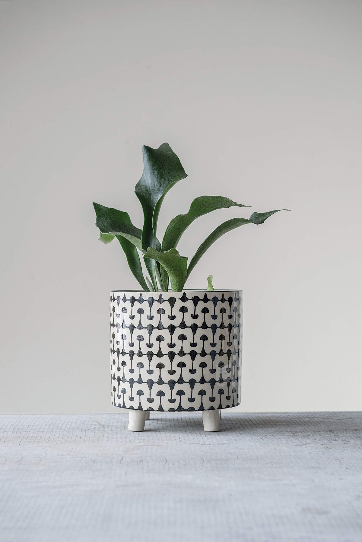 Creative Co-Op round stoneware planter with black and white finish, elevating spaces indoors or outdoors.
