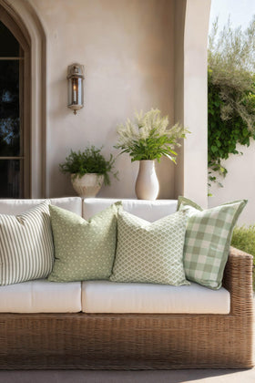 Crumbs Home indoor-outdoor palm design pillow cover shown on a couch and patio chair