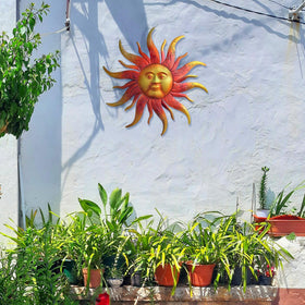 Daogtc sun face wall decor outdoors, adds warmth to gardens and patios.