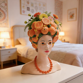 Head planter on windowsill with orange crown and greenery
