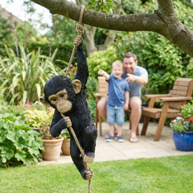 The Enchanted Garden monkey ornament hangs from a fence or pergola to spark conversation.