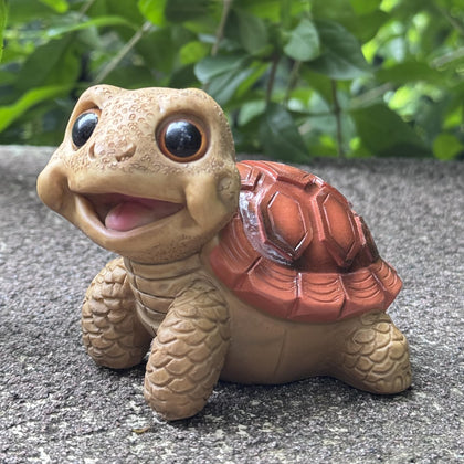 EOREA Mini Funny Turtle Garden Statue on a patio adds whimsical charm to outdoor spaces.