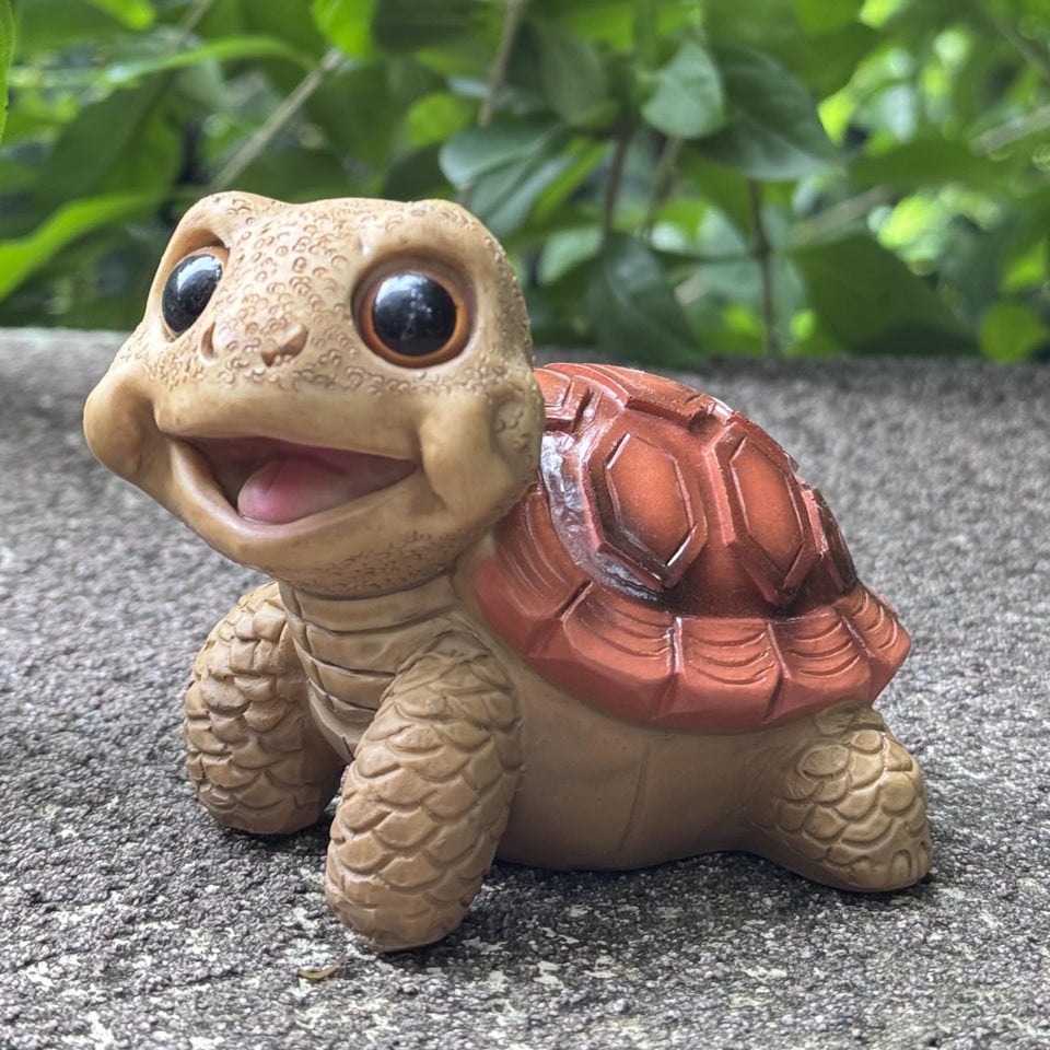 EOREA Mini Funny Turtle Garden Statue on a patio adds whimsical charm to outdoor spaces.