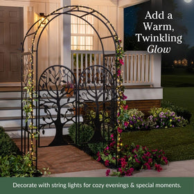 Evergreen iron trellis arch serving as focal point in patio or garden walkway.