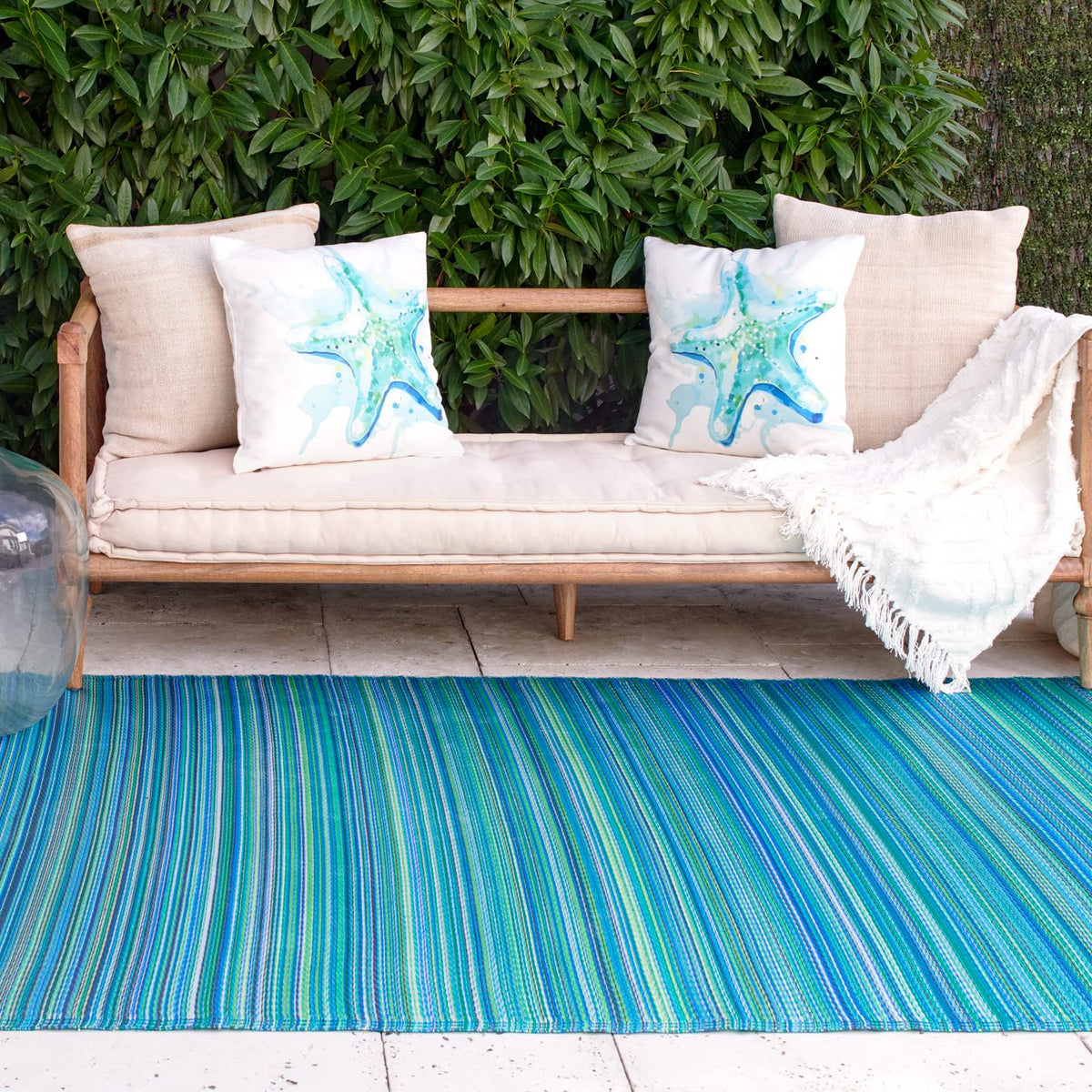 Fab Habitat Cancun stripe outdoor rug on a sunny patio adds vibrant color and style.