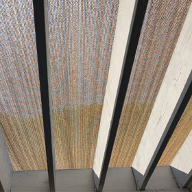 Fence4ever brown shade fabric roll edge being cut to fit a custom space