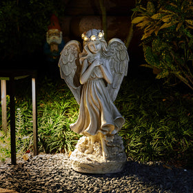 Floryden praying angel statue with solar light illuminates paths at night.