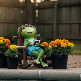 Flytime frog reading figurine serves as a playful garden focal point