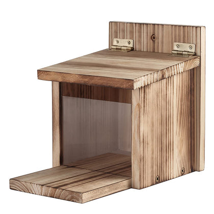 Freezing Point wooden squirrel feeder with movable cover in a backyard, protecting nuts from rain.