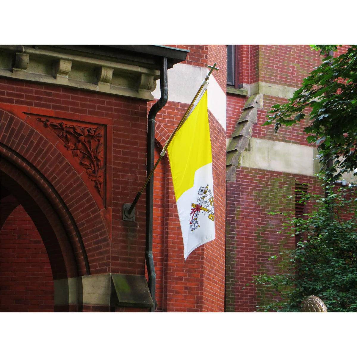 FRF FLAG Vatican flag displayed outdoors in garden or on wall for celebration.