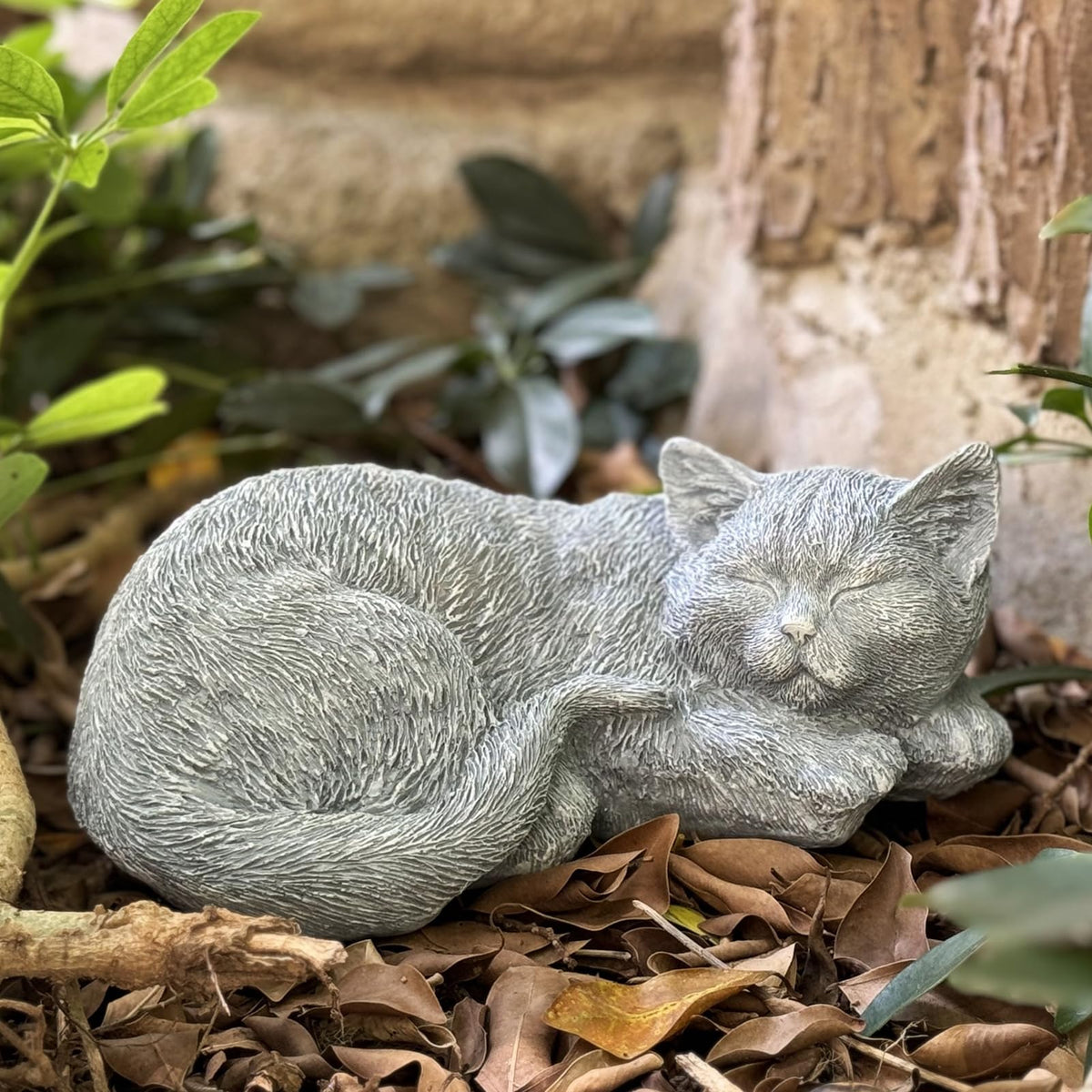 Garden Whisper cat memorial statue laying in the garden for serene remembrance.