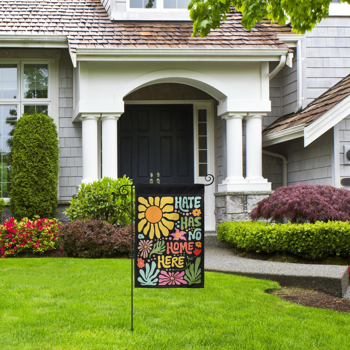 Generic Hate Has No Home Here flag, colorful message for garden spaces.