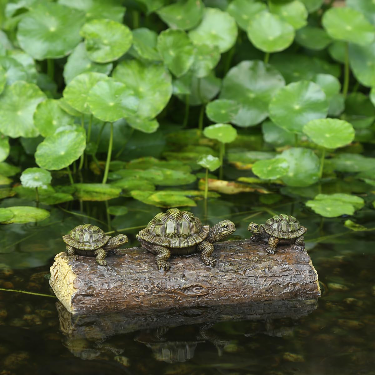 Generic three-turtle sculptures on a log enhance pond decor with natural charm.