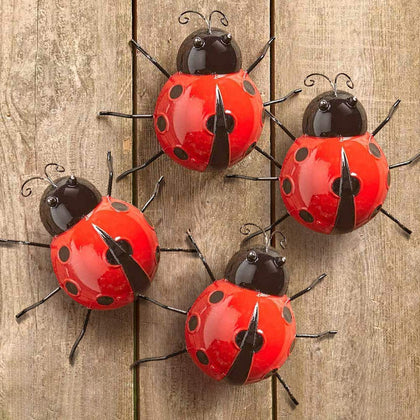 Gudui metal ladybugs on garden wall add playful outdoor charm.