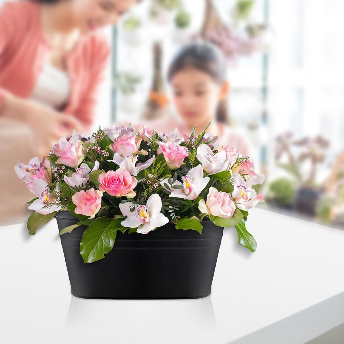 Floral arrangement on patio using GYATSOCYG oval planters for vibrant decoration.