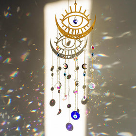 H&D HYALINE & DORA evil eye suncatcher on a window adds color reflections.