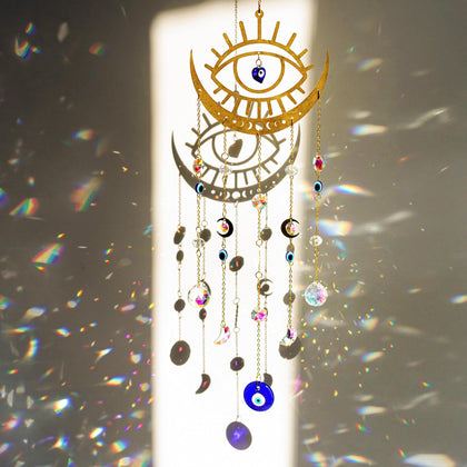 H&D HYALINE & DORA evil eye suncatcher on a window adds color reflections.