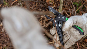 Hooyman ratchet pruner in use trimming a branch.