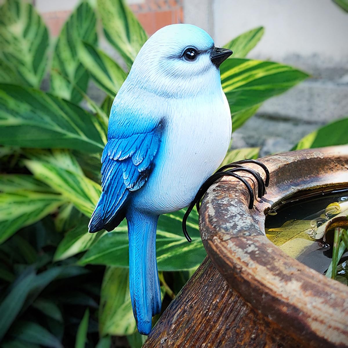 Jarpsiry garden bird statue with blue feathers sits on a branch.