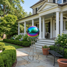 JforSJizT rainbow gazing ball shines in sunlight, enhancing outdoor decor.