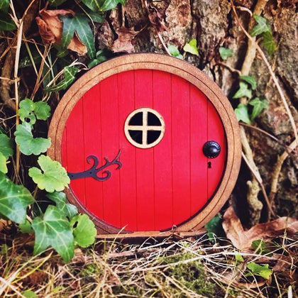 Jinshining Red Fairy Door on tree front view enhances outdoor garden charm.