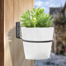 Jiozermi wall-mounted metal planter hanger in matte black elevates exterior or interior decor.
