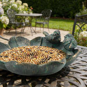 Juliahestia decorative birdbath on patio enhances garden ambiance.