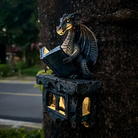 Solar-powered light glows softly from the dragon's book at dusk
