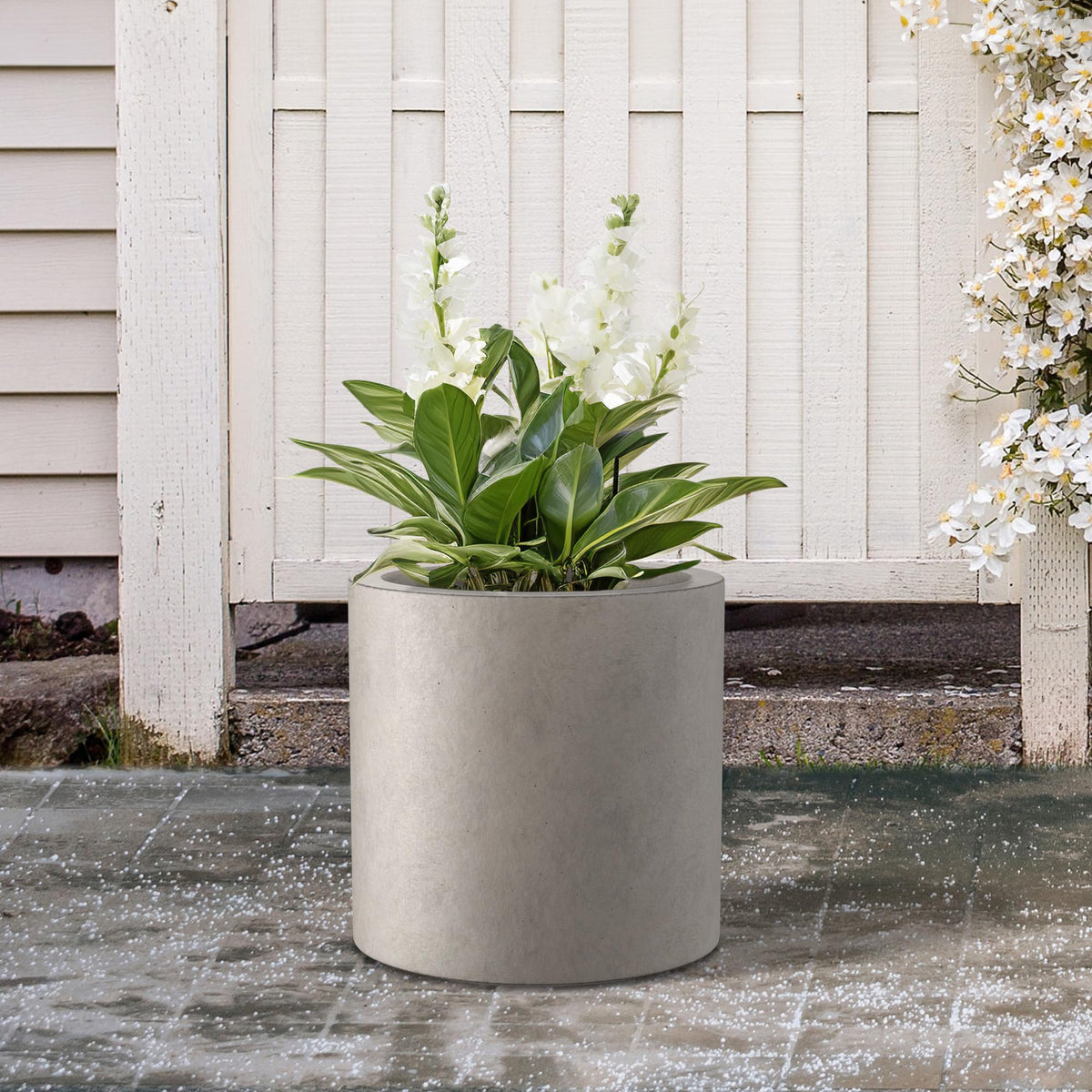 Kante round concrete planter outdoors, blends with patio decor.