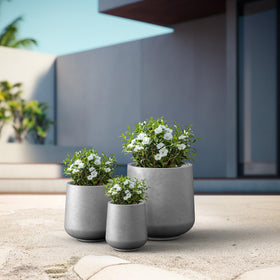 Kante round concrete planter weather-resistant design withstands wind and seasonal changes.