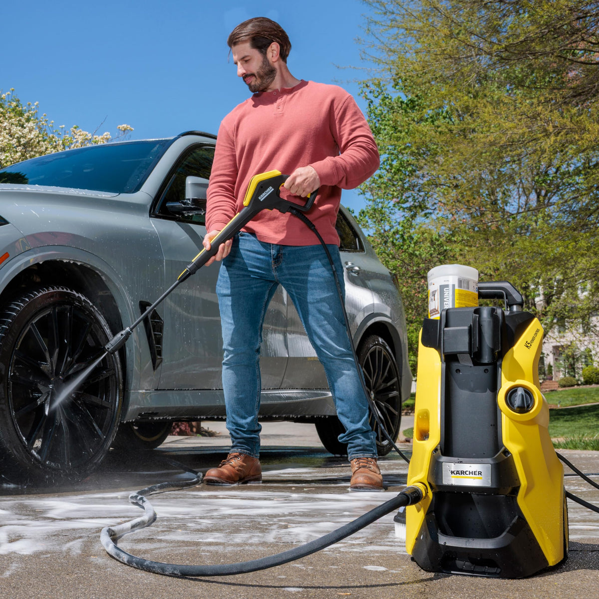 Karcher K5 DirtBlaster spray blasts grime on concrete surfaces.