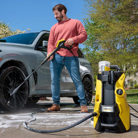 Karcher K5 DirtBlaster spray blasts grime on concrete surfaces.