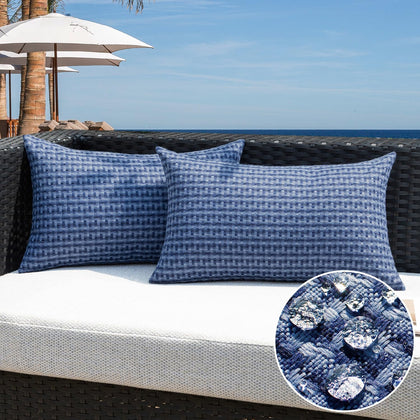 Kevin Textile navy blue outdoor pillow cover pack-2 shown on a chair outdoors.