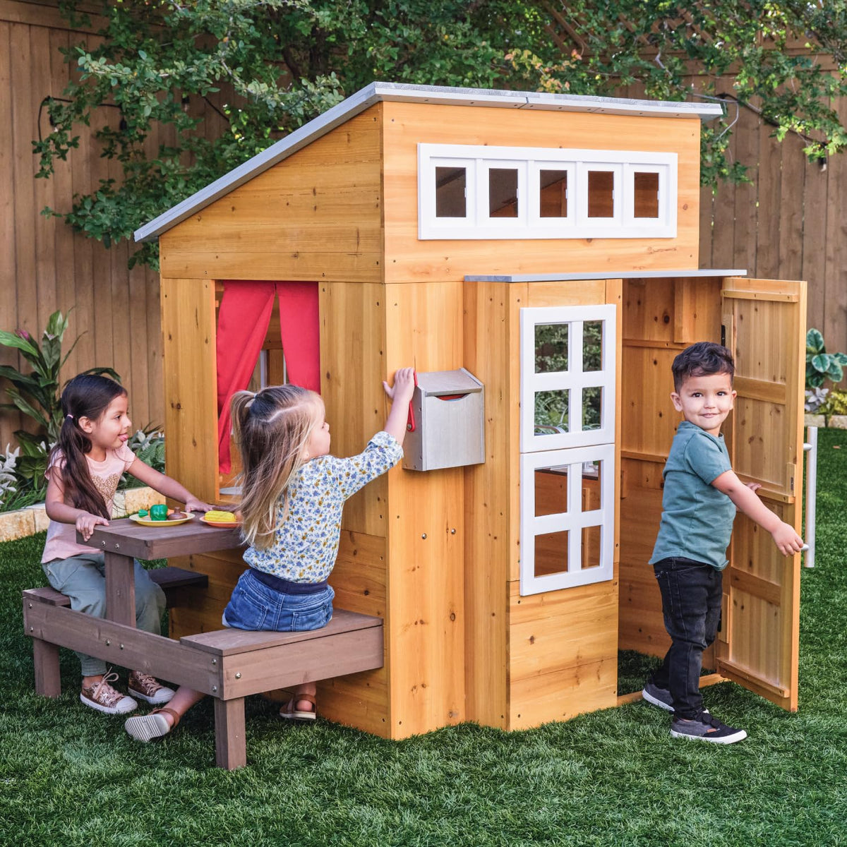 KidKraft Playhouse with picnic table invites shared pretend meals in the yard.
